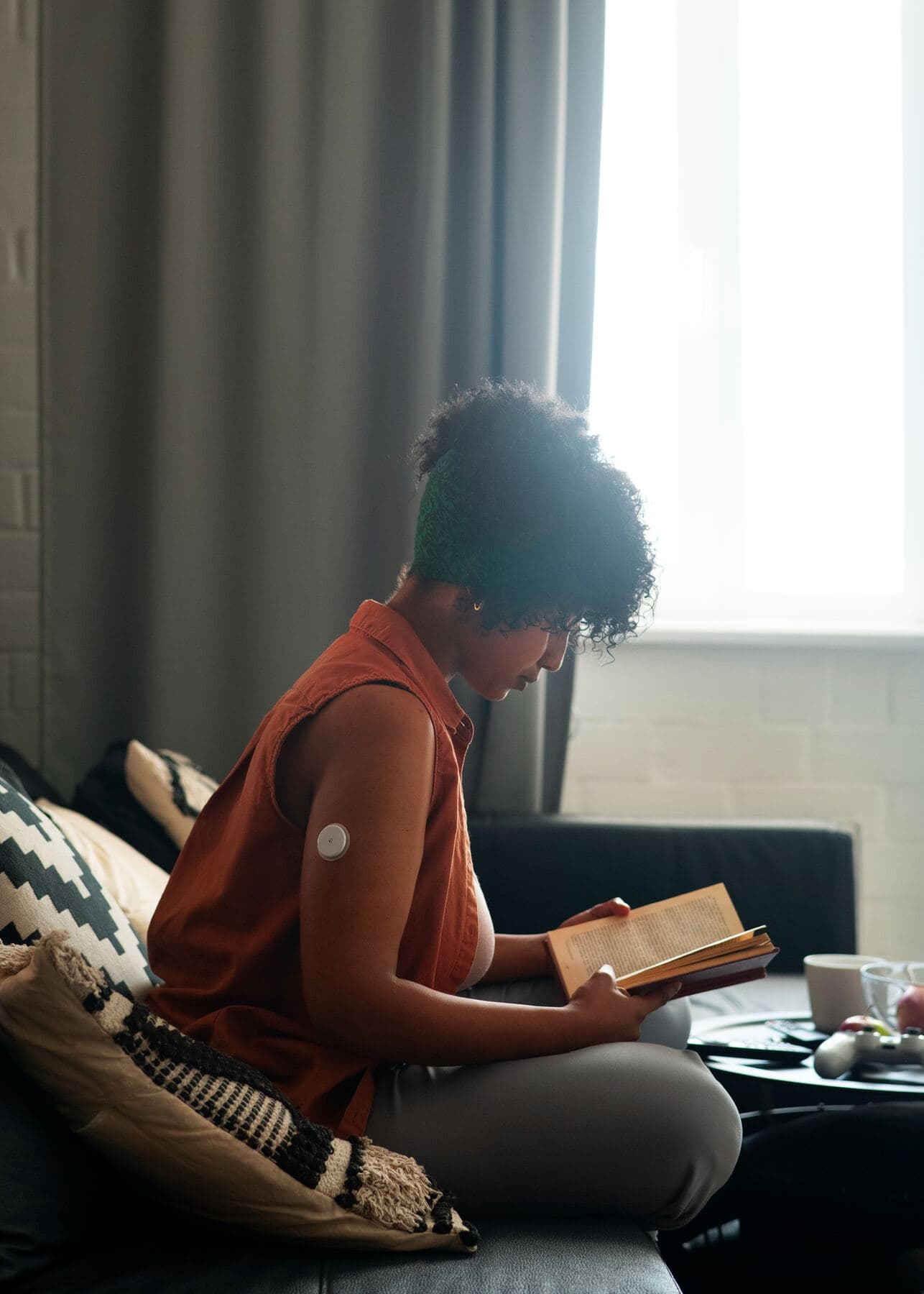 A woman reading in a bright room by a window